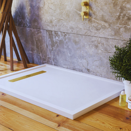 A modern bathroom featuring a white shower with a linear shower tray and a vibrant potted plant for a touch of nature.